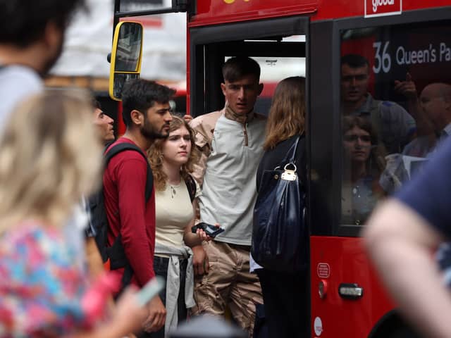 Passengers squeeze onto a red London bus outside Victoria Station London, in August 2022 (Photo: HOLLIE ADAMS/AFP via Getty Images)