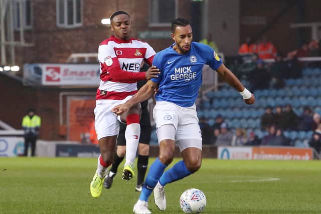 Rhys Bennett of Peterborough United in action with Cameron John of Doncaster Rovers. Photo: Joe Dent/theposh.com.