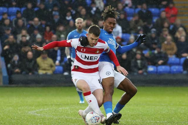 Ivan Toney of Peterborough United battles for the ball with Ben Whiteman of Doncaster Rovers. Photo: Joe Dent/theposh.com.