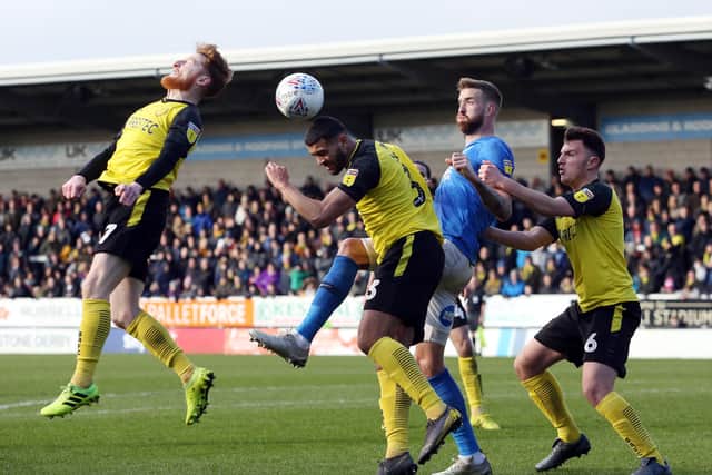 Mark Beevers of Peterborough United challenges for the ball with Stephen Quinn, Colin Daniel and Kieran Wallace of Burton Albio. Photo: Joe Dent/theposh.com.