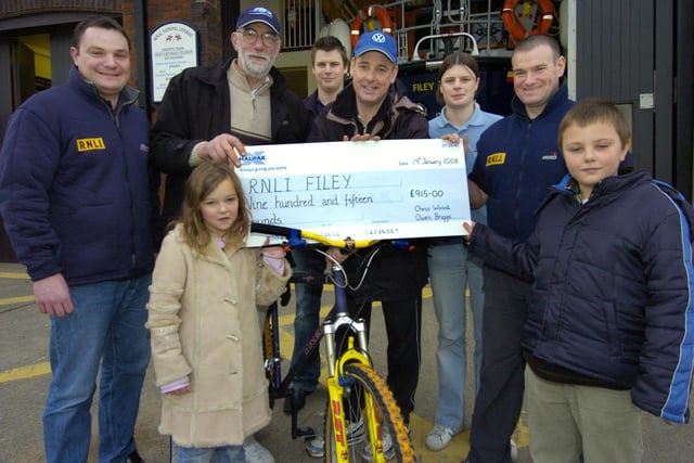 Fundraising cyclists Owen Briggs, second left, and Chris Wood, fourth left, accompanied by Chris' children Olivia and Charlie Wood present a cheque for £915 to Filey lifeboat crew members, from left, Richard Johnson, Matthew Wilkins, Fran Wilkins and Neil Cammish.