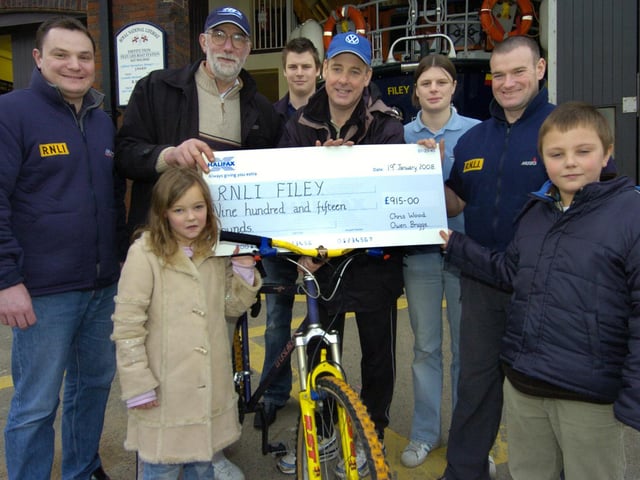 Fundraising cyclists Owen Briggs, second left, and Chris Wood, fourth left, accompanied by Chris' children Olivia and Charlie Wood present a cheque for £915 to Filey lifeboat crew members, from left, Richard Johnson, Matthew Wilkins, Fran Wilkins and Neil Cammish.
