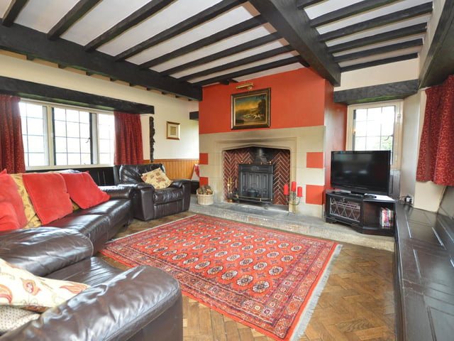 This room oozes character from its fireplace to its church pew seating, beams and parquet flooring.