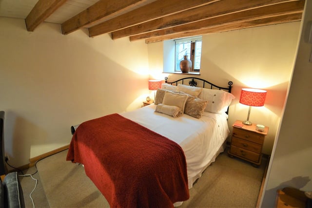 A more cosy double bedroom, with character beams and window.
