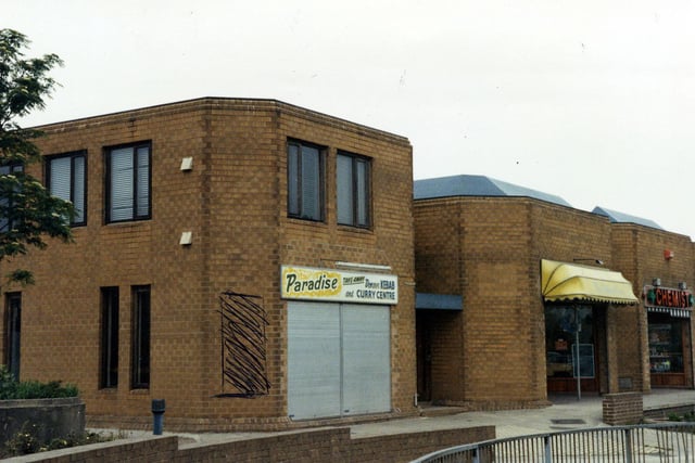 The Fraternity House complex on Church Street in Hunslet in May 1990. It includes the Paradise Kebab and Curry Centre in the foreground and a chemist on the right.