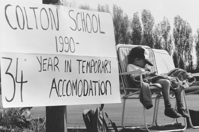 A small boy sleeps through protests at the Colton Lane polling station for a new school in the village.