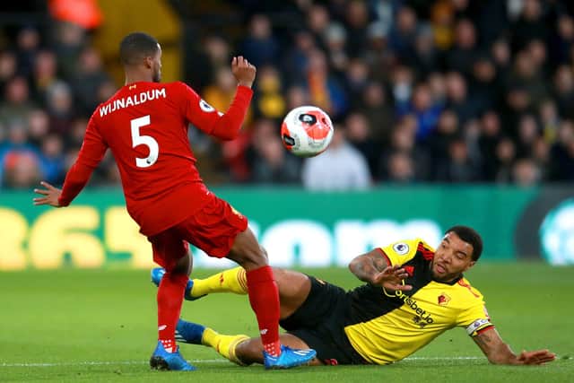 Troy Deeney (yellow) playing for Watford against Liverpool. Photo: Adam Davy PA.