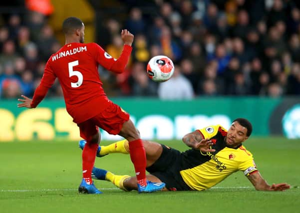 Troy Deeney (yellow) playing for Watford against Liverpool. Photo: Adam Davy PA.