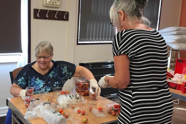 CARESCO's Gill Robinson, left, and Pat Ayres busy sorting strawberries for 90 afternoon teas. EMN-200307-125940001