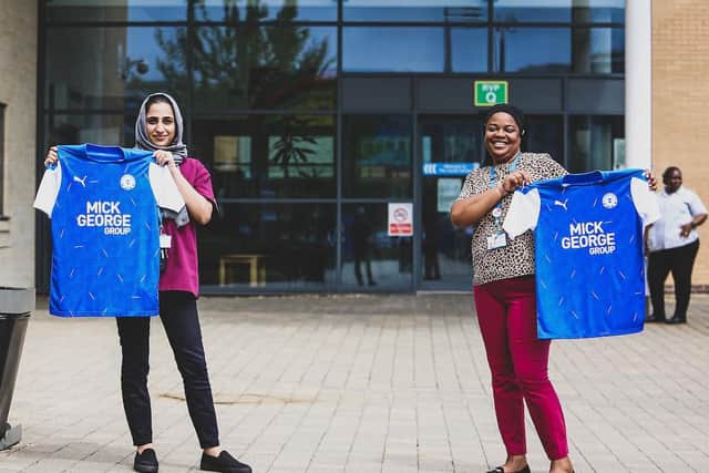 Key workers show off the new Posh home shirt.