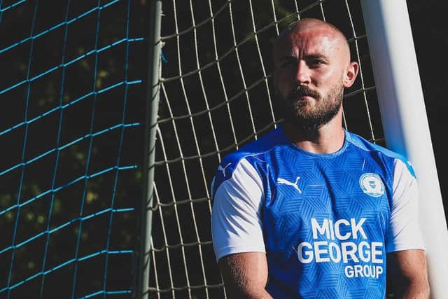 Posh player Dan Butler models the new home shirt.