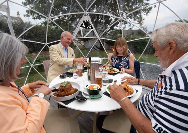 Diners enjoy a meal inside one of the outdoor dining pods which have been installed for social distancing at The Barn Restaurant, Terrington St John, near Wisbech, as it reopens following the easing of coronavirus lockdown restrictions across England. Photo: Joe Giddens/PA Wire