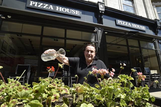 Rinaldo Fasulo watering the flowers outside his Pizza House in Cowgate, which opened on Saturday.