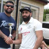 Kasim Ikhlaq (right) receives a bowling award from match sponsor Sunny Singh of Peterborough Cars.