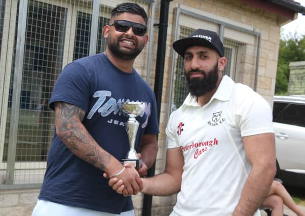 Kasim Ikhlaq (right) receives a bowling award from match sponsor Sunny Singh of Peterborough Cars.