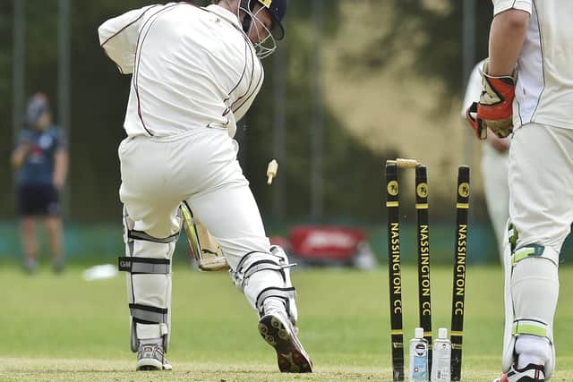 A sign of the times as hand sanitiser is placed behind the stumps in the game between Nassington and Stamford. Photo: David Lowndes.