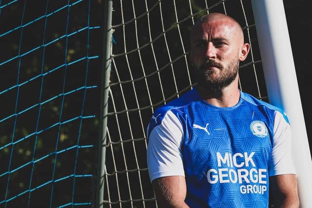 Posh defender Dan Butler models the new Posh home shirt.