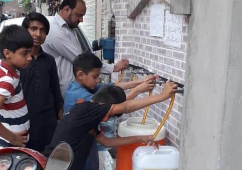 Families accessing the safe water near the Lahore offices of AA Labels.