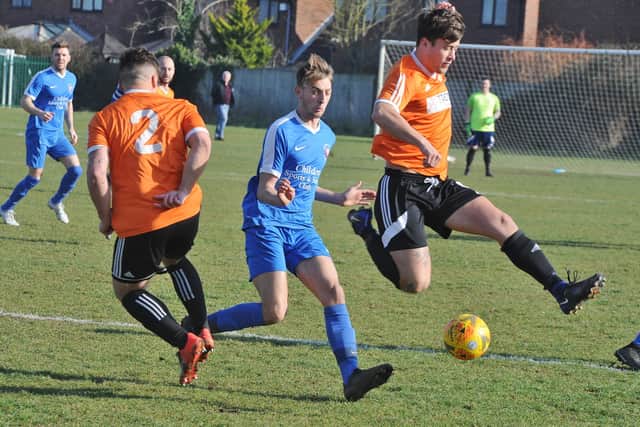 Thorney FC (orange) in action.