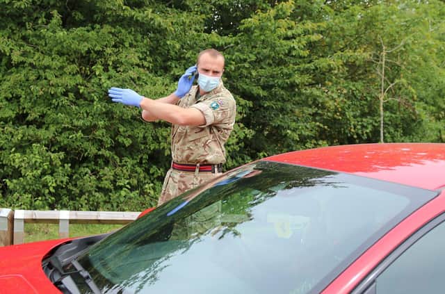 Reservist Captain Benjamin Parker, 200 Squadron 158 Regiment Royal Logistic Corps giving direction to vehicle driver on what would happen during the Covid-19 Testing procedure at the Parklands Leisure Centre Carpark.    On Thursday 23rd July 2020, British Army Soldiers were deployed to Covid-19 Virus Mobile Testing Units within the Leicester area. The Mobile testing units were also staffed by various National Health Service Track and Trace Personnel. The two locations within the area of Leicester which were involved were:  Prajapati Hall Community Centre and Parklands Leisure Centre.  Content Creator:  D. Garry Fox/ MOD Crown. EMN-200730-143504001