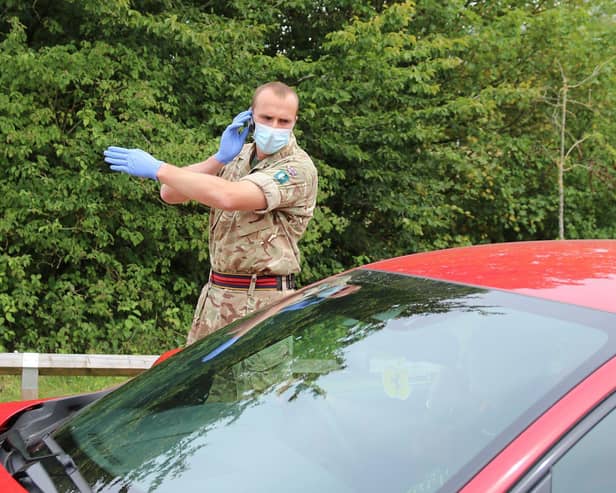 Reservist Captain Benjamin Parker, 200 Squadron 158 Regiment Royal Logistic Corps giving direction to vehicle driver on what would happen during the Covid-19 Testing procedure at the Parklands Leisure Centre Carpark.    On Thursday 23rd July 2020, British Army Soldiers were deployed to Covid-19 Virus Mobile Testing Units within the Leicester area. The Mobile testing units were also staffed by various National Health Service Track and Trace Personnel. The two locations within the area of Leicester which were involved were:  Prajapati Hall Community Centre and Parklands Leisure Centre.  Content Creator:  D. Garry Fox/ MOD Crown. EMN-200730-143504001