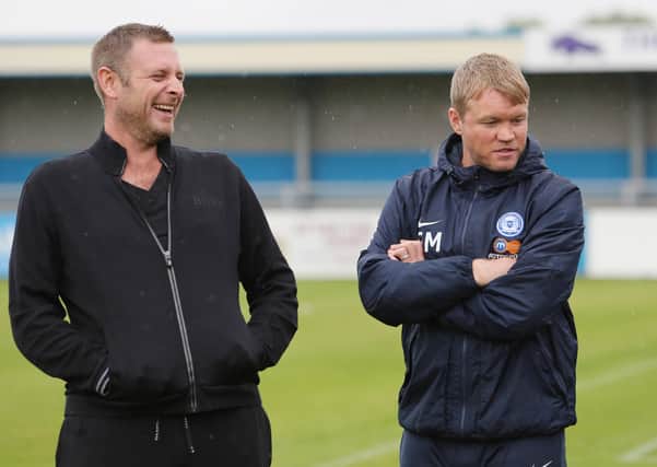 Darragh MacAnthony (left) and former Posh manager Grant McCann.