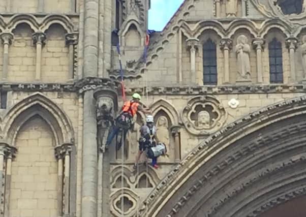 Stonemason Kate Holmes and colleagues  from Architectural & Heritage Scanning Ltd abseils down Peterborough Cathedral to carry out a laser scan. Pictures: David Lowndes