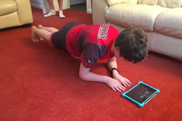 Lewis Tarver watches the time during his 75 second plank challenge