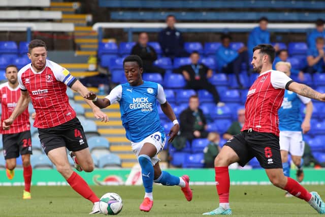 Siriki Dembele of Peterborough United skips past Ben Tozer and Chris Clements of Cheltenham Town. Photo: Joe Dent/theposh.com.
