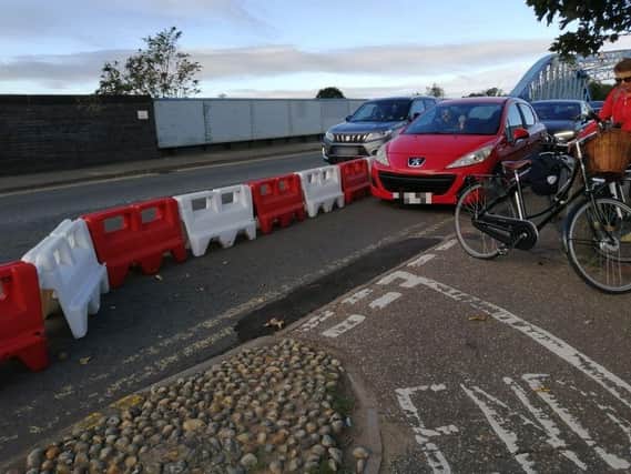 The cars were seen squeezing down the cycle lane this morning