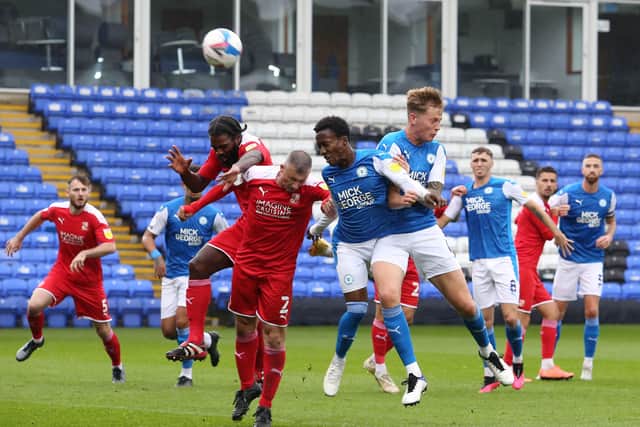 Siriki Dembele and Frankie Kent of Peterborough United challenge for the ball with Swindon's Anthony Grant and Paul Caddis. Photo: Joe Dent/theposh.com.
