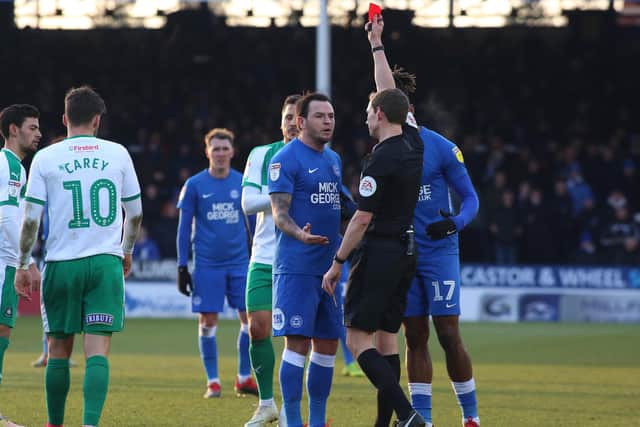 Lee Tomlin receives a red card while playing for Posh.