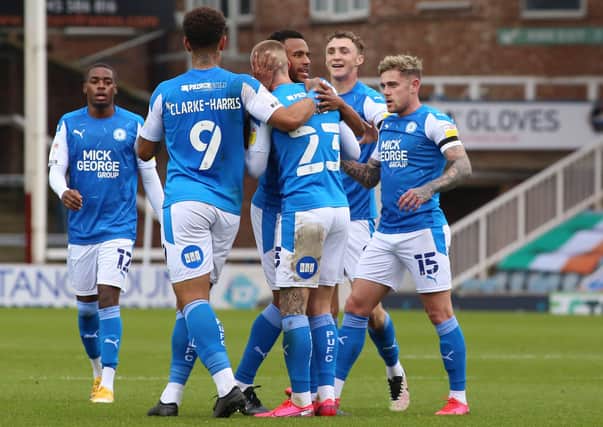 Joe Ward of Peterborough United is congratulated by team-mates after scoring the opening goal of the game against Oxford. Photo: Joe Dent/theposh.com.