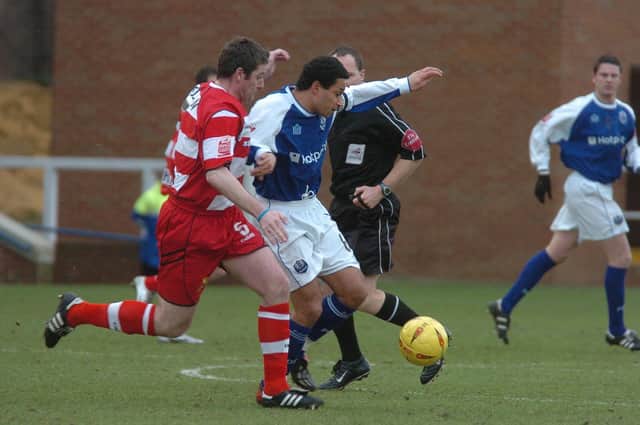 Curtis Woodhouse (blue) in action for Posh.