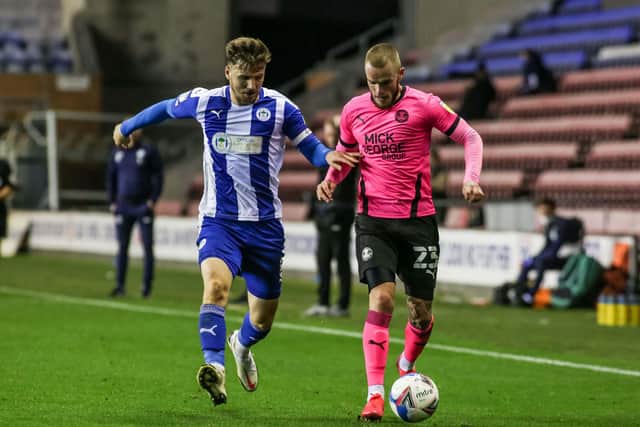 Posh winger Joe Ward in action with Lee Evans of Wigan Athletic. Photo: Joe Dent/theposh.com.
