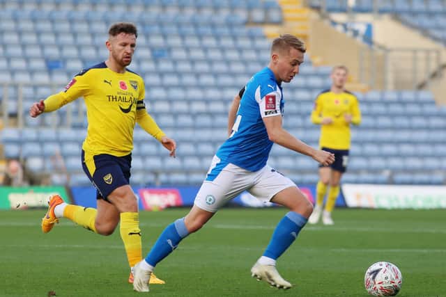Louis Reed of Peterborough United in action with Matty Taylor of Oxford United. Photo: Joe Dent/theposh.com.
