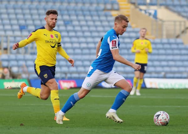 Louis Reed of Peterborough United in action with Matty Taylor of Oxford United. Photo: Joe Dent/theposh.com.