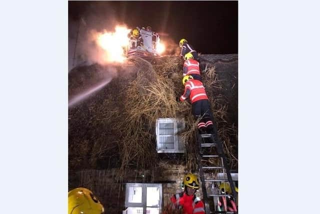 Fire fighters tackle the blaze at the thatched roof cottage on High Street, Castor.
