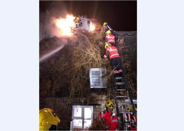 Fire fighters tackle the blaze at the thatched roof cottage on High Street, Castor.