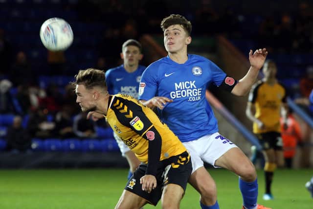 Harrison Burrows (blue) in action for Posh against Cambridge United in their last meeting in 2019.