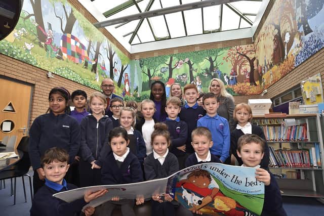 Orton Wistow primary school headteacher Simon Eardley with staff and pupils at their school library which has a new overhead mural. EMN-201011-112924009