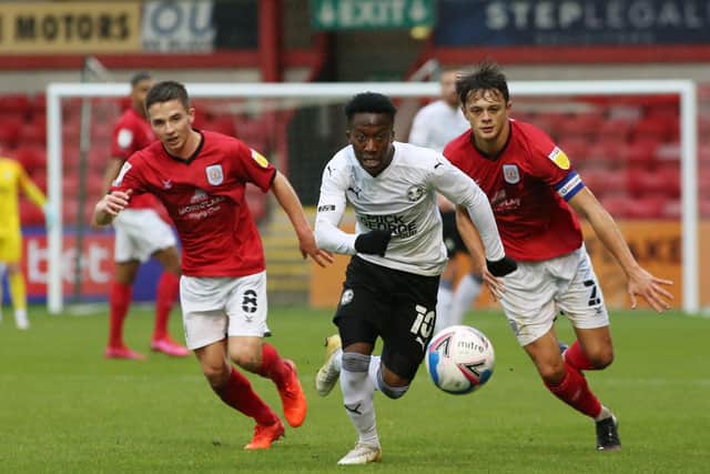 Siriki Dembele of Peterborough United gets away from Tom Lowery and Perry Ng of Crewe Alexandra. Photo: Joe Dent/theposh.com