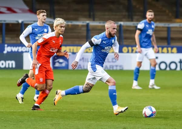 Posh star Joe Ward in action with Kenny Dougall of Blackpool at the weekend. Photo: Joe Dent/theposh.com.