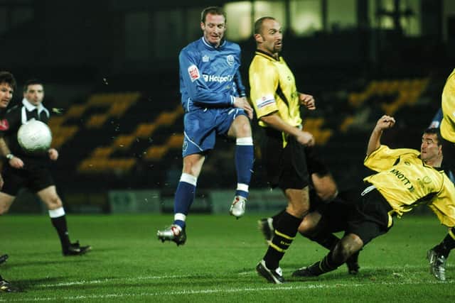 Peter Gain (blue) in action for Posh at Burton Albion in a first round FA Cup replay.