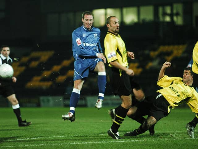 Peter Gain (blue) in action for Posh at Burton Albion in a first round FA Cup replay.