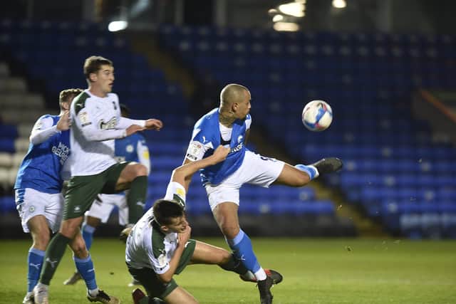 Posh striker Jonson Clarke-Harris has his shirt pulled by a Plymouth defender. Photo: David Lowndes.