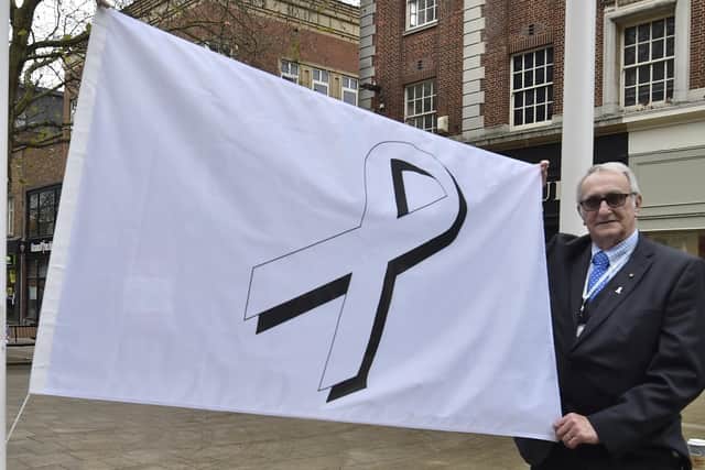 Cllr John Holdich raising the White Ribbon flag outside the Town Hall