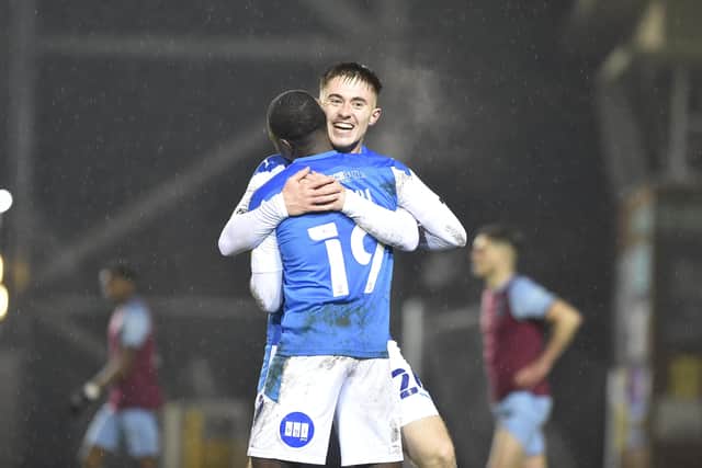 Flynn Clarke helps Mo Eisa celebrate his goal for Posh against West Ham. Photo: David Lowndes.