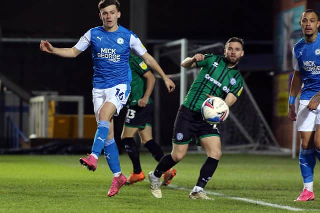 Harrison Burrows of Peterborough United in action with Jimmy Ryan of Rochdale. Photo: Joe Dent/theposh.com.