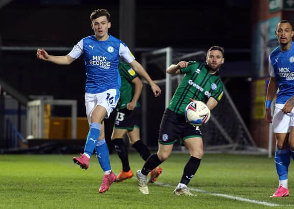 Harrison Burrows of Peterborough United in action with Jimmy Ryan of Rochdale. Photo: Joe Dent/theposh.com.